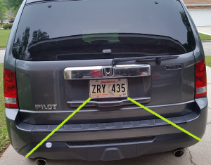 Place decal, horizontally, somewhere along the green line between the corner of the license plate and the corner of the bumper. Either side is acceptable.